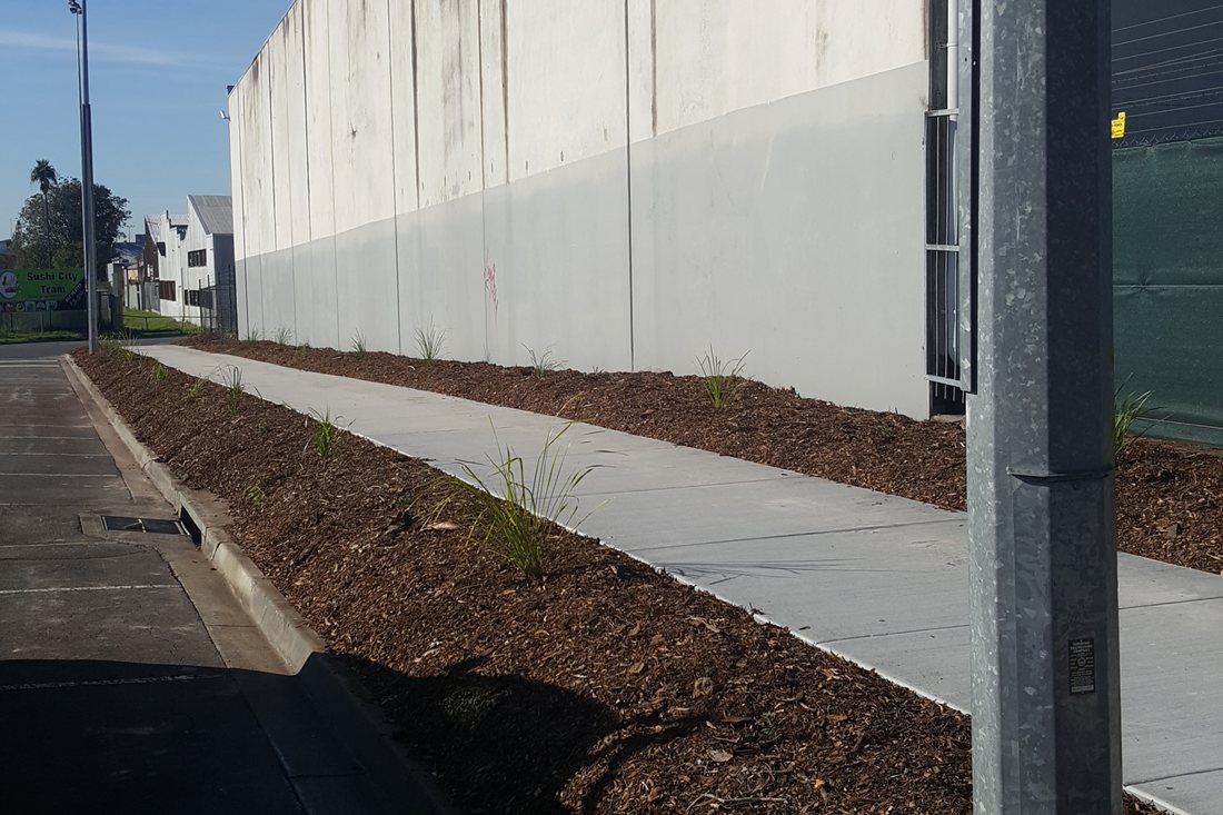 Stafford City — finished footpath alongside the brick wall with fresh mulch bed